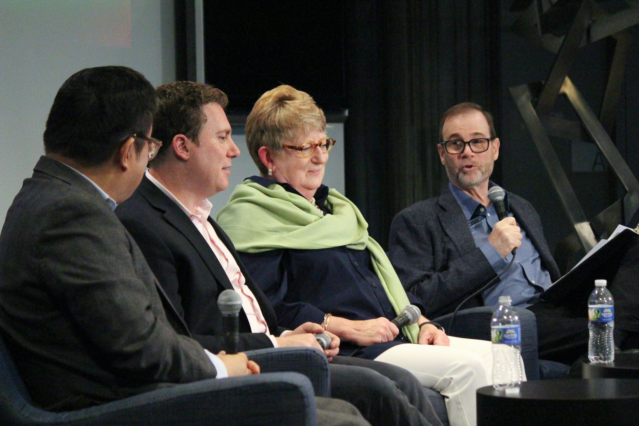 Moderator Stephen Adler with three panelists onstage.